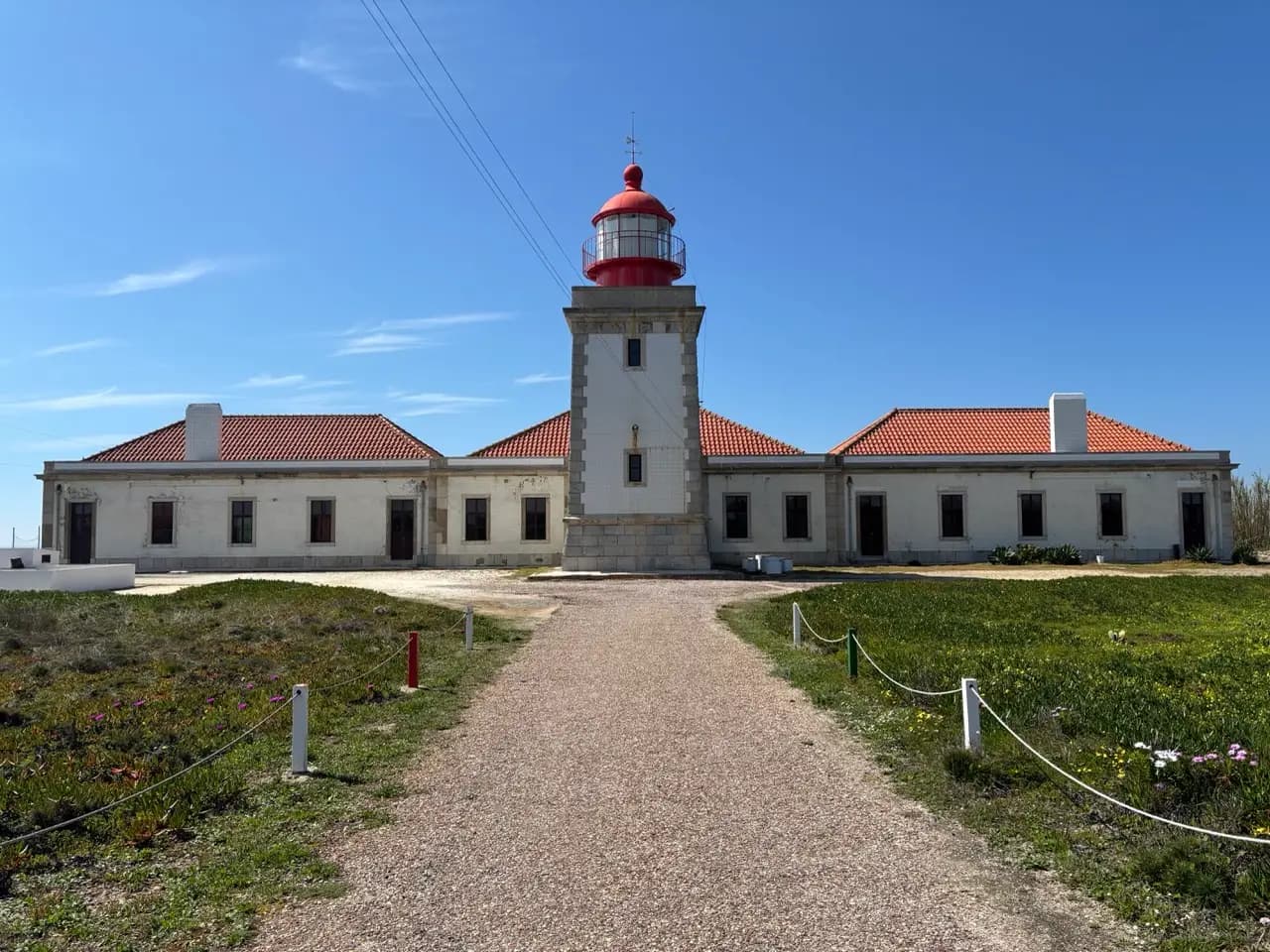 A lighthouse on the Portuguese coast with a red dome and white walls