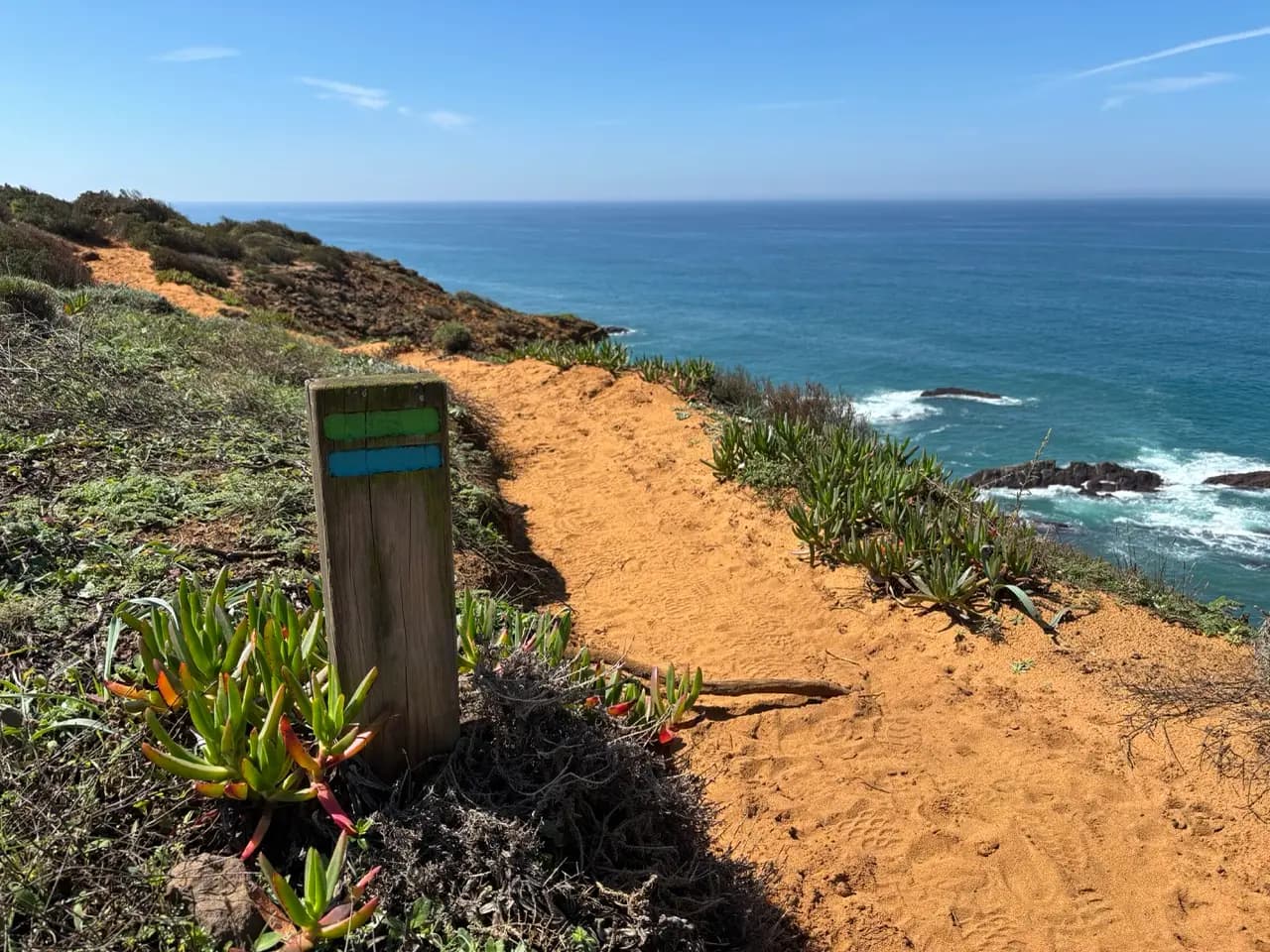Orange Rota Vicentina waymarks along the path