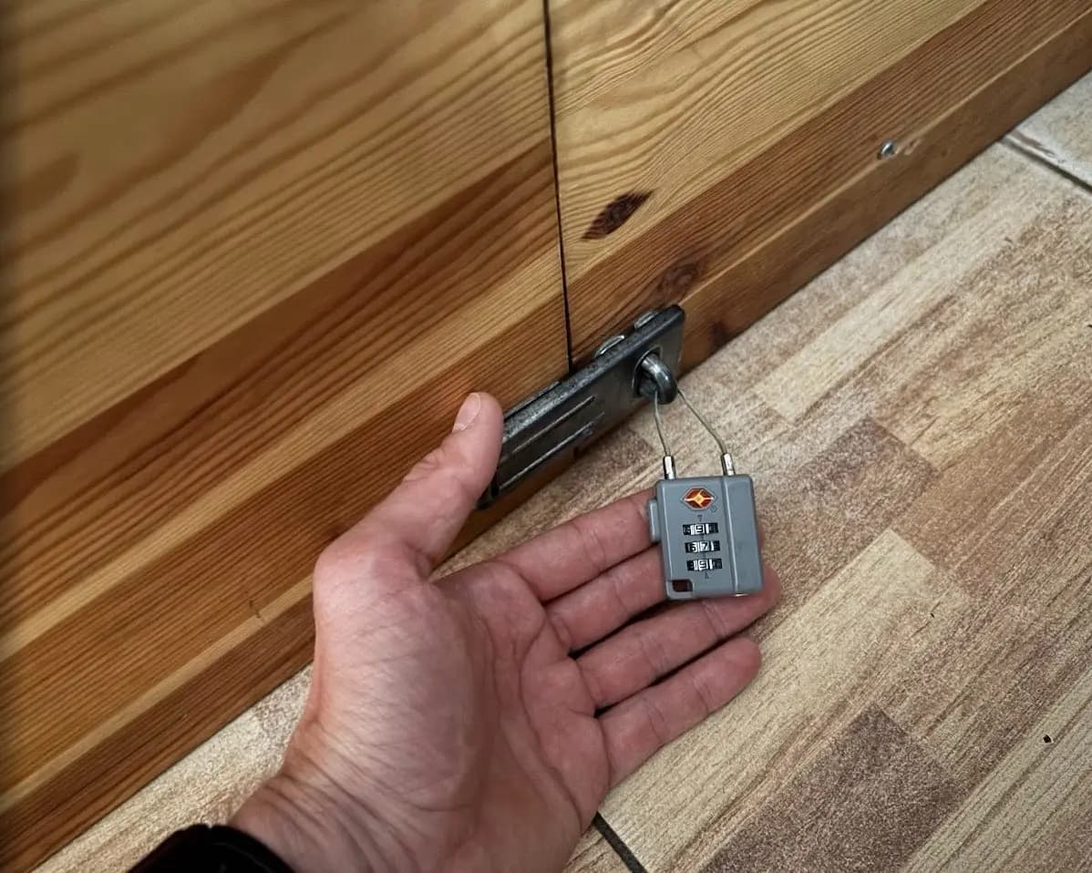 A small padlock securing a hostel locker on the Fishermen's Trail