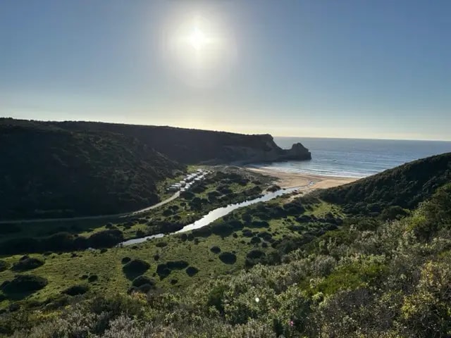Sunlit beach and river valley seen from above on the Fishermen's Trail