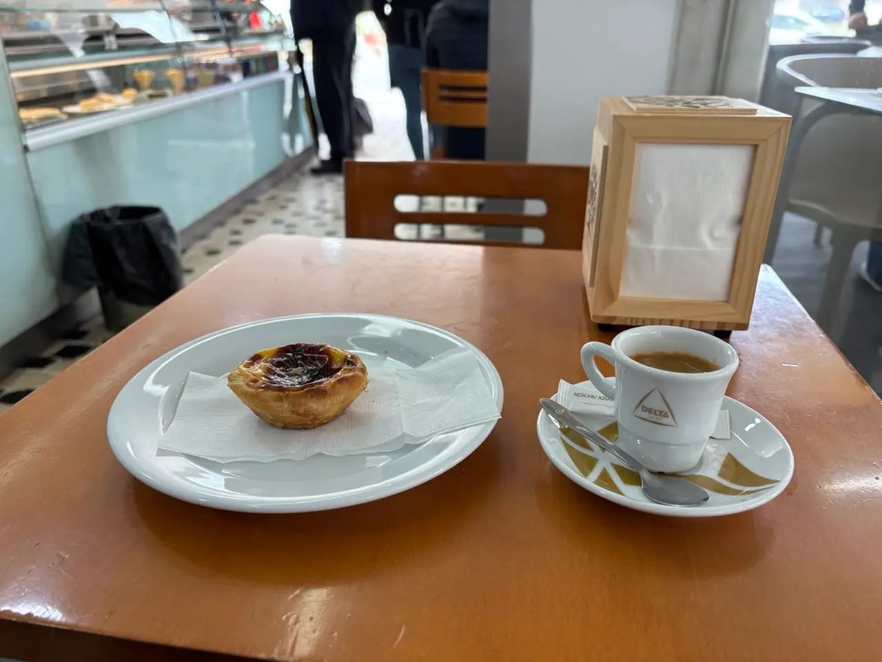 Pastel de nata custard tart and espresso on a café table