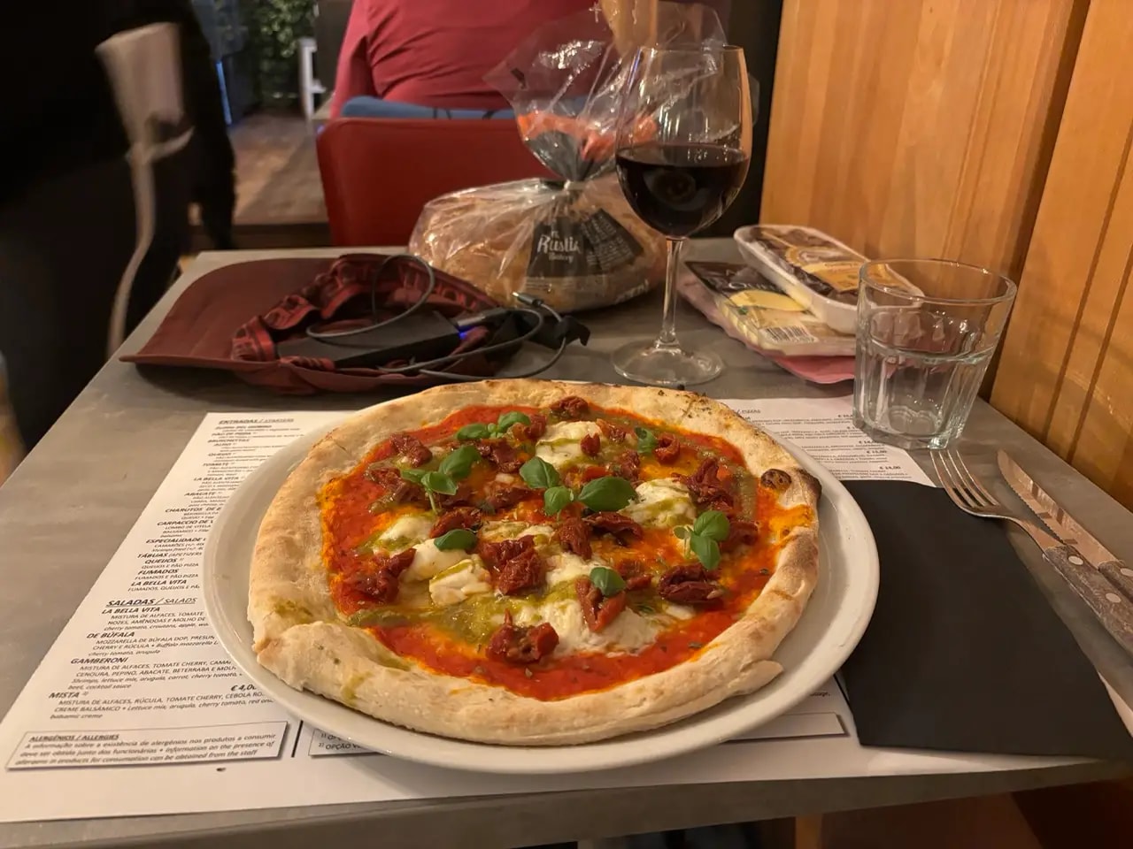 Thin-crust pizza with mozzarella, pesto and basil on a restaurant table