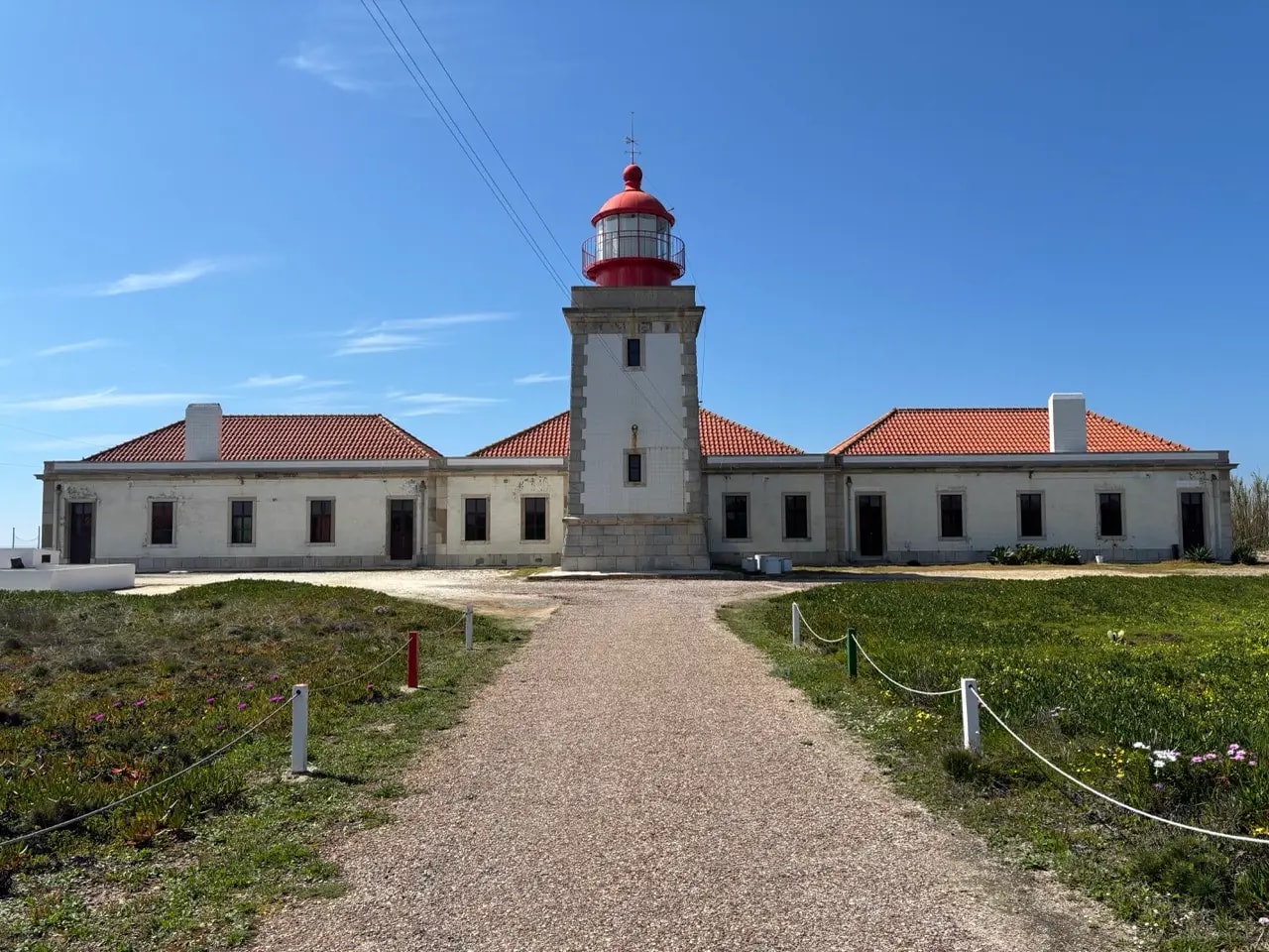 A lighthouse on the Portuguese coast with a red dome and white walls A lighthouse on the Portuguese coast with a red dome and white walls